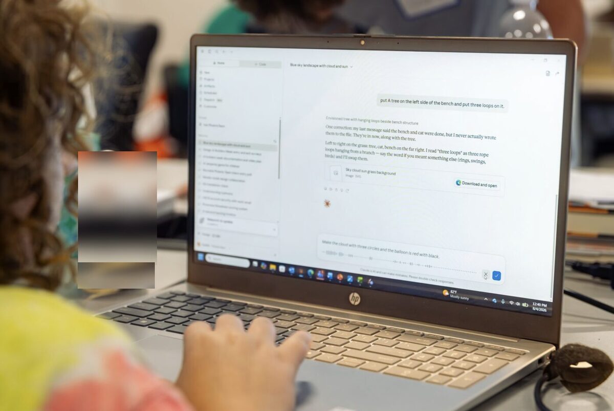 A young participant builds a scene by prompting an AI tool on her laptop