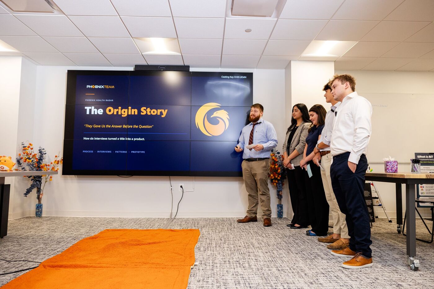 A pod presents The Origin Story slide for Phoenix Health Radar to the room
