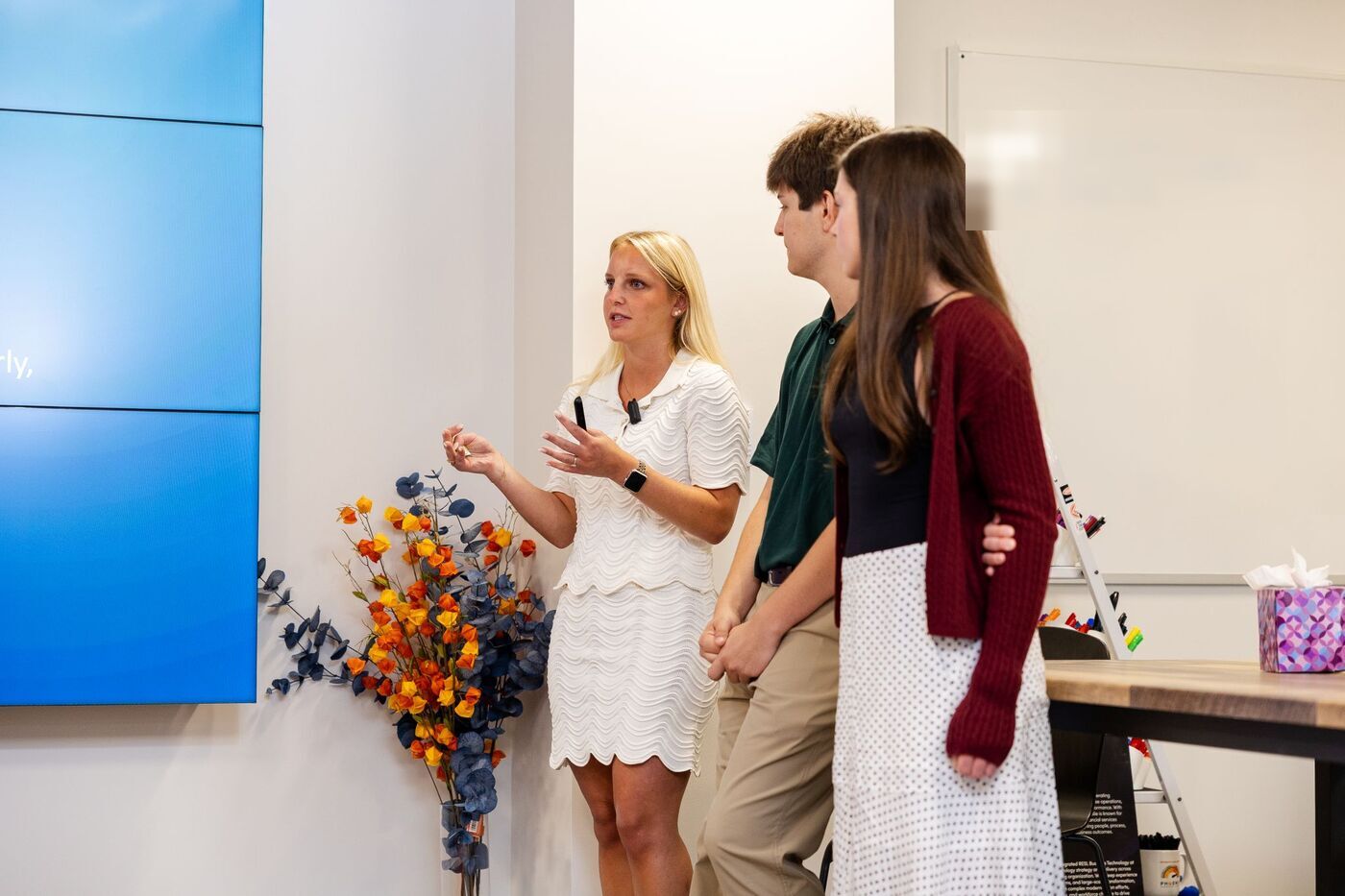 Three interns present together at the front of the room