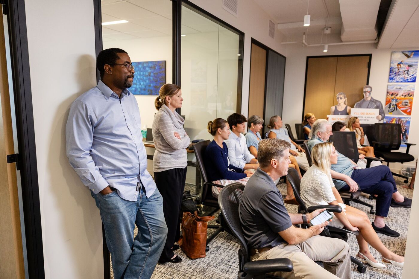 PhoenixTeam staff watch the presentations from the back of the room